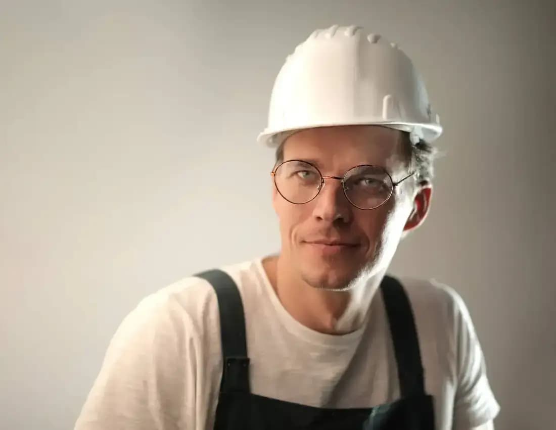 Profissional da construção sorrindo com capacete de segurança